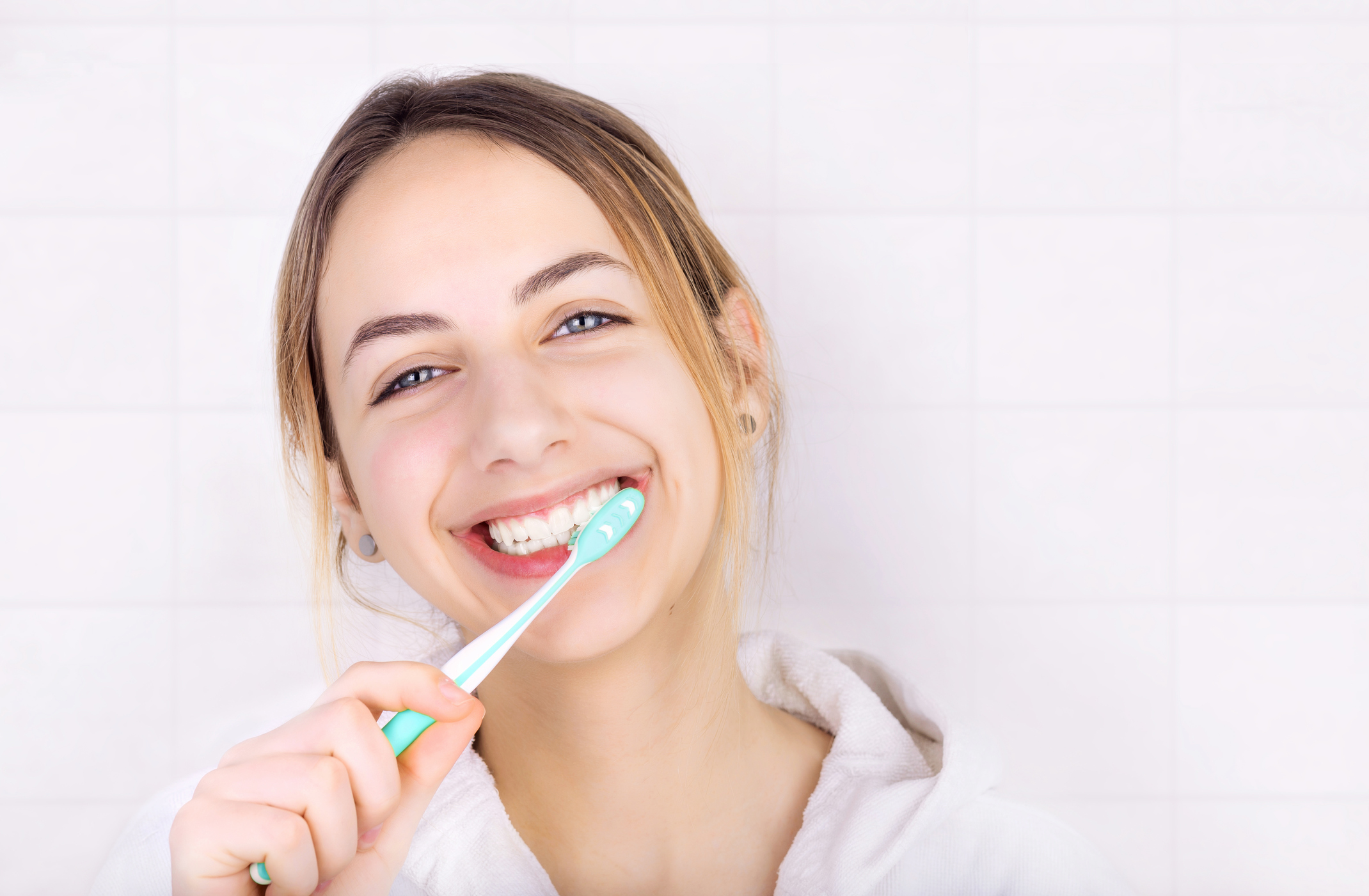 Happy young woman brushing teeth . Happy young woman brushing teeth .